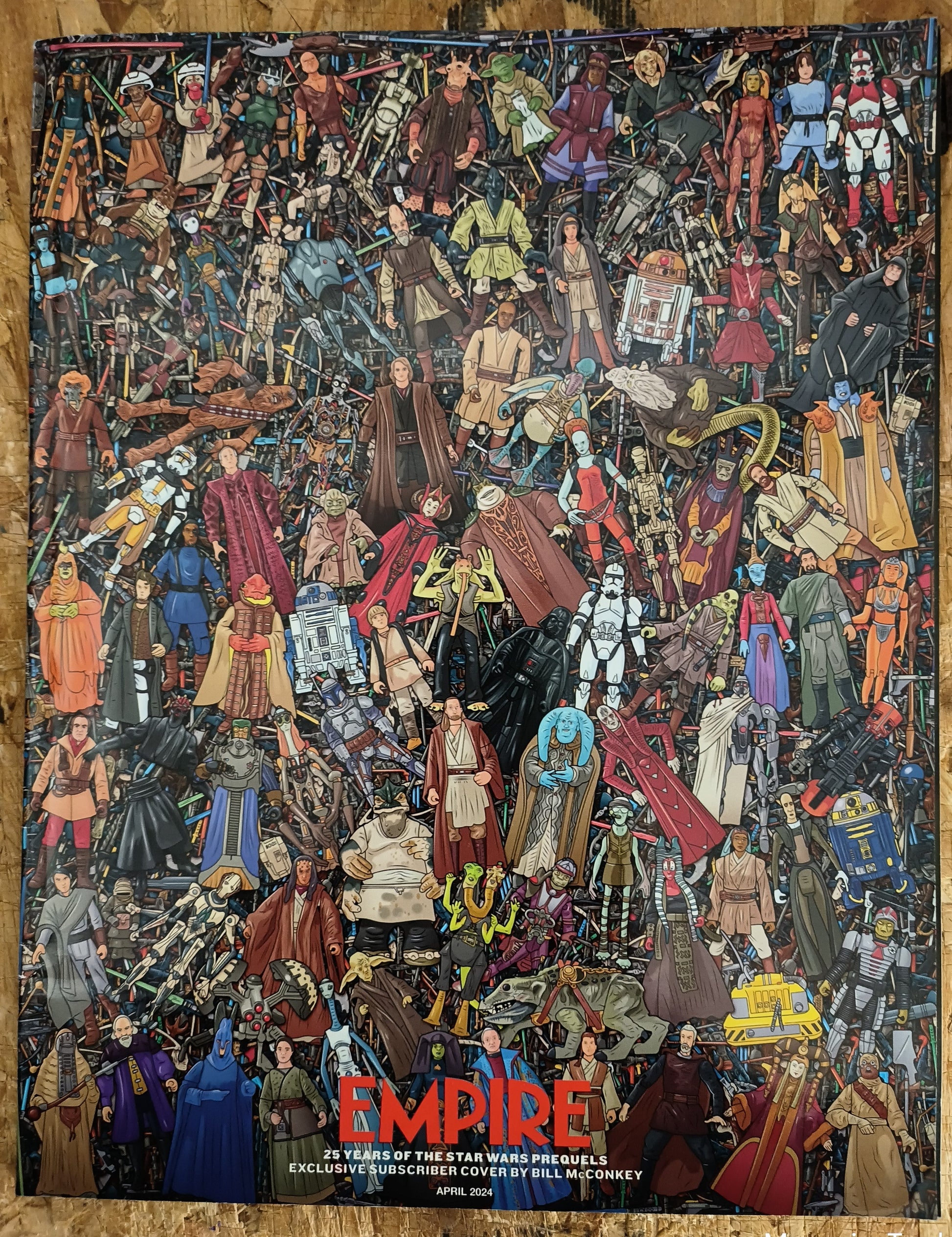 Collection of Star Wars action figures arranged in a mosaic pattern on a wooden surface.